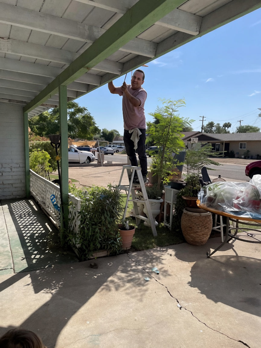 Gerardo painting exterior porch beams on a residential home