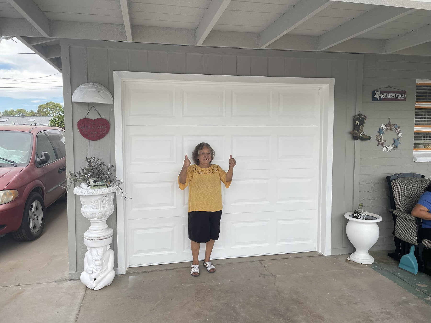 Satisfied homeowner standing in front of a freshly painted garage
